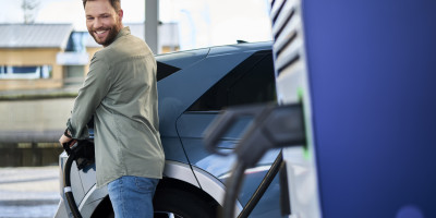 Un homme recharge sa voiture sur le chargeur électrique Q8